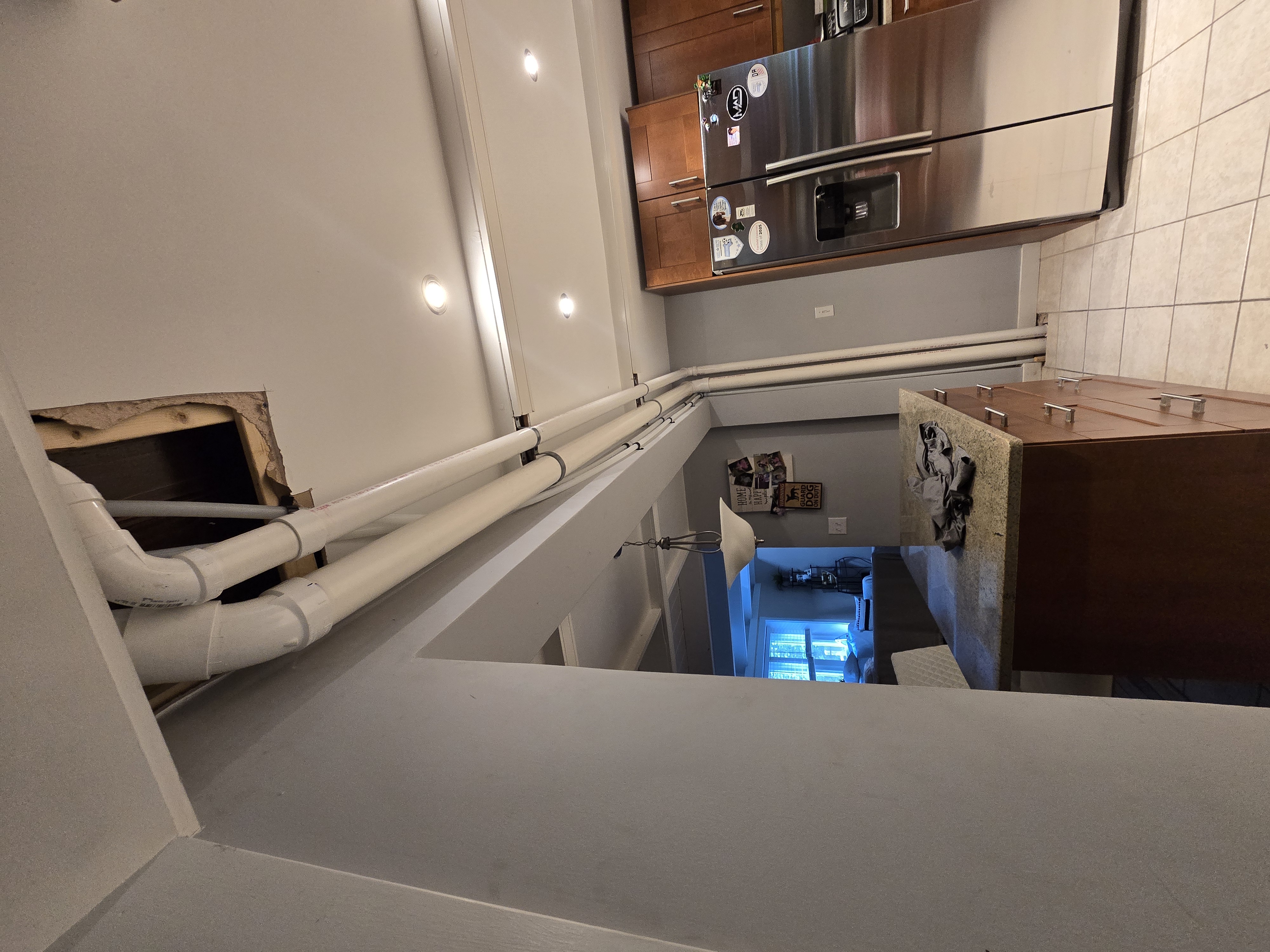 Access panel cut for rough plumbing above kitchen ceiling