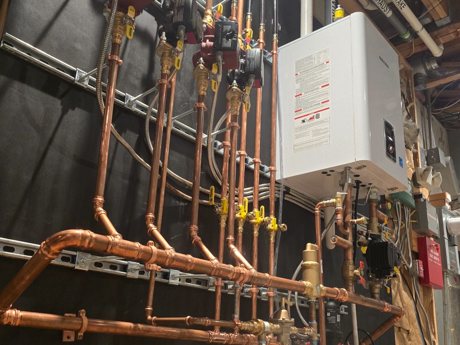 Navien wall-hung boiler with copper hydronic manifold and zone circulators