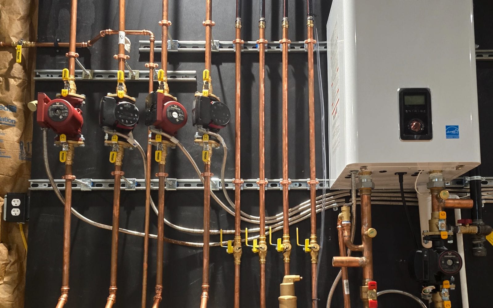 Navien high-efficiency boiler installation with four-zone copper manifold and circulators